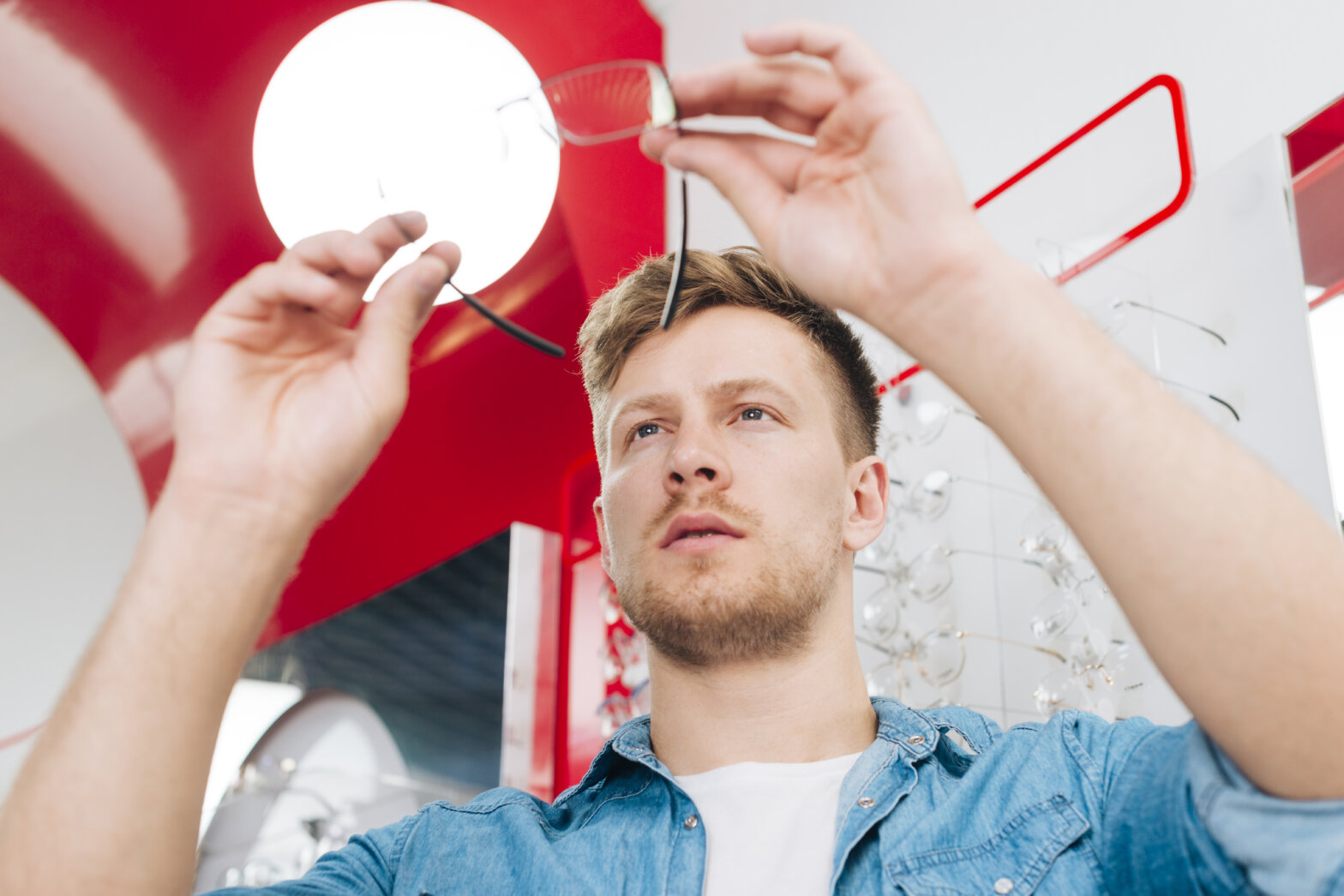 Vendas de fim de ano. Homem observando óculos em óptica.